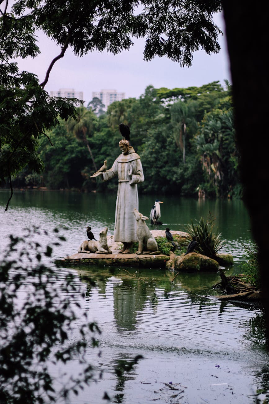 sculpture of francis of assisi with animals on river